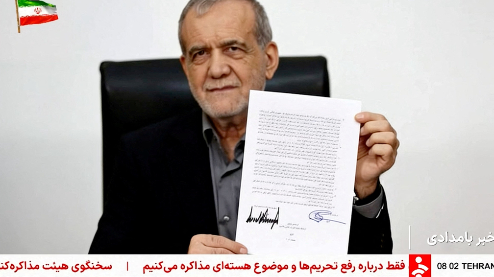 Uma captura de tela mostra o presidente iraniano, Masoud Pezeshkian, segurando o memorando assinado por ele e pelo presidente dos EUA, Donald Trump. — Foto: Reuters