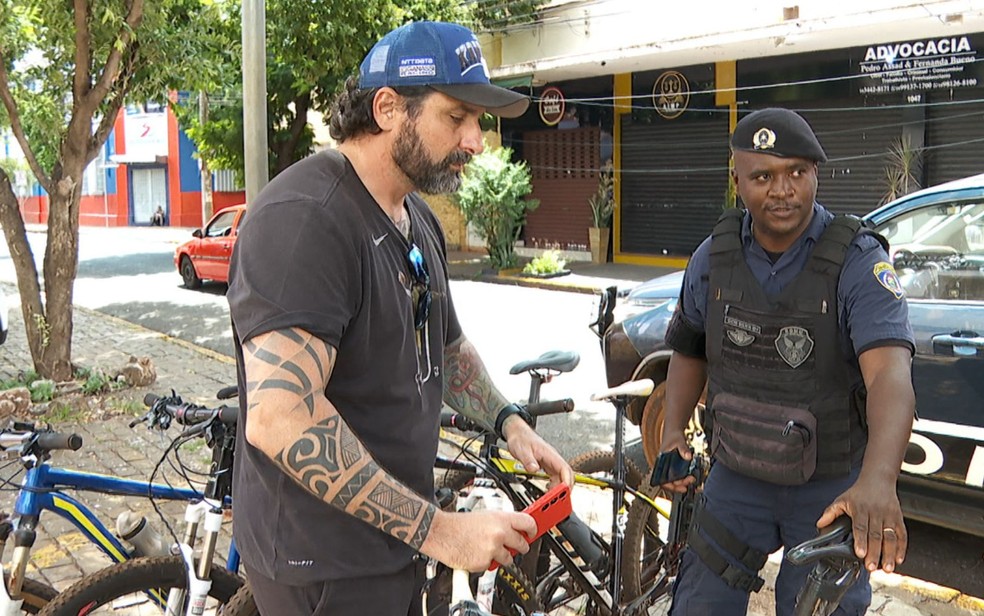 Ciclista Guilherme Zeri junto a guarda municipal Lucas Silva em Ribeirão Preto (SP) — Foto: Reprodução/EPTV