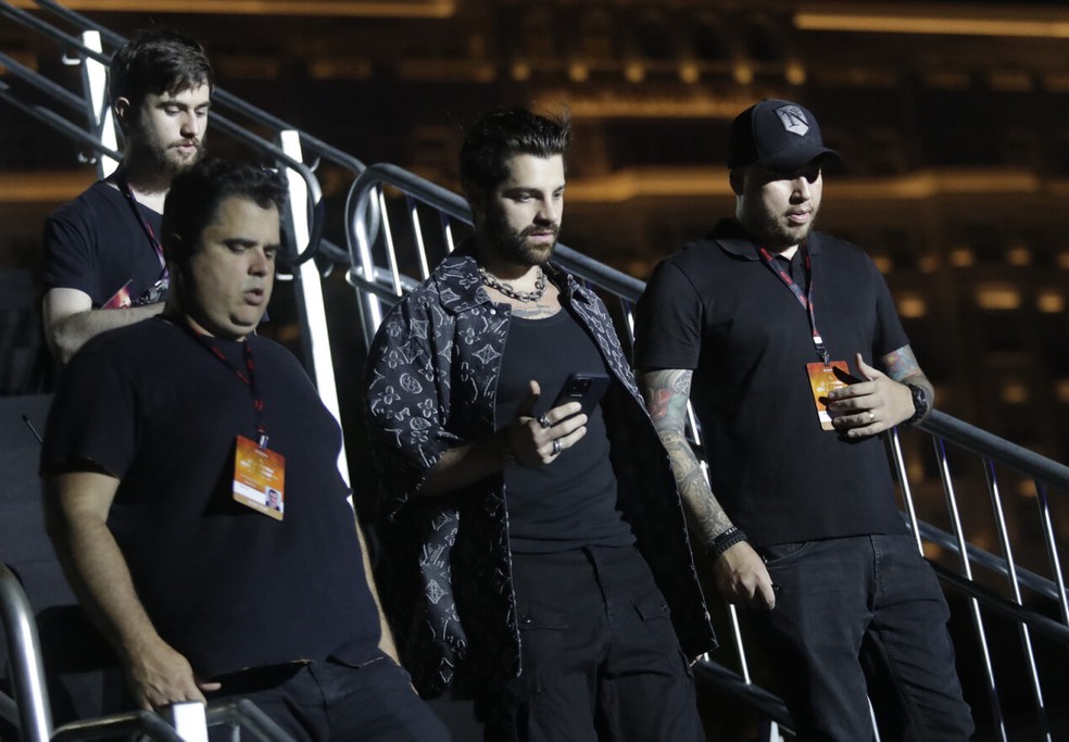 O DJ Alok, ao centro, chega ao ensaio do Show do Século — Foto: Bruna Prado/AP