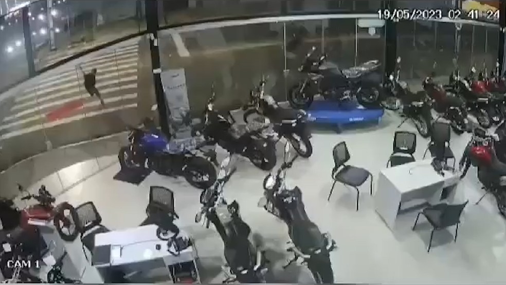 Suspeito usou uma pedra para arrombar a loja de motos, em Mangabeira, na Zona Sul de João Pessoa — Foto: Reprodução/TV Cabo Branco