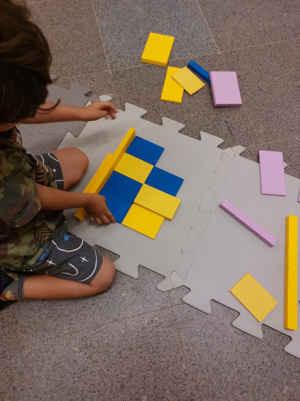 Criança brinca com pedaços de papel coloridos. — Foto: Diculgação CCBB