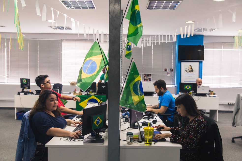 Funcionários trabalham na startup GetNinjas, que enfeitou o ambiente de trabalho para os jogos da Copa do Mundo — Foto: Marcelo Brandt/G1