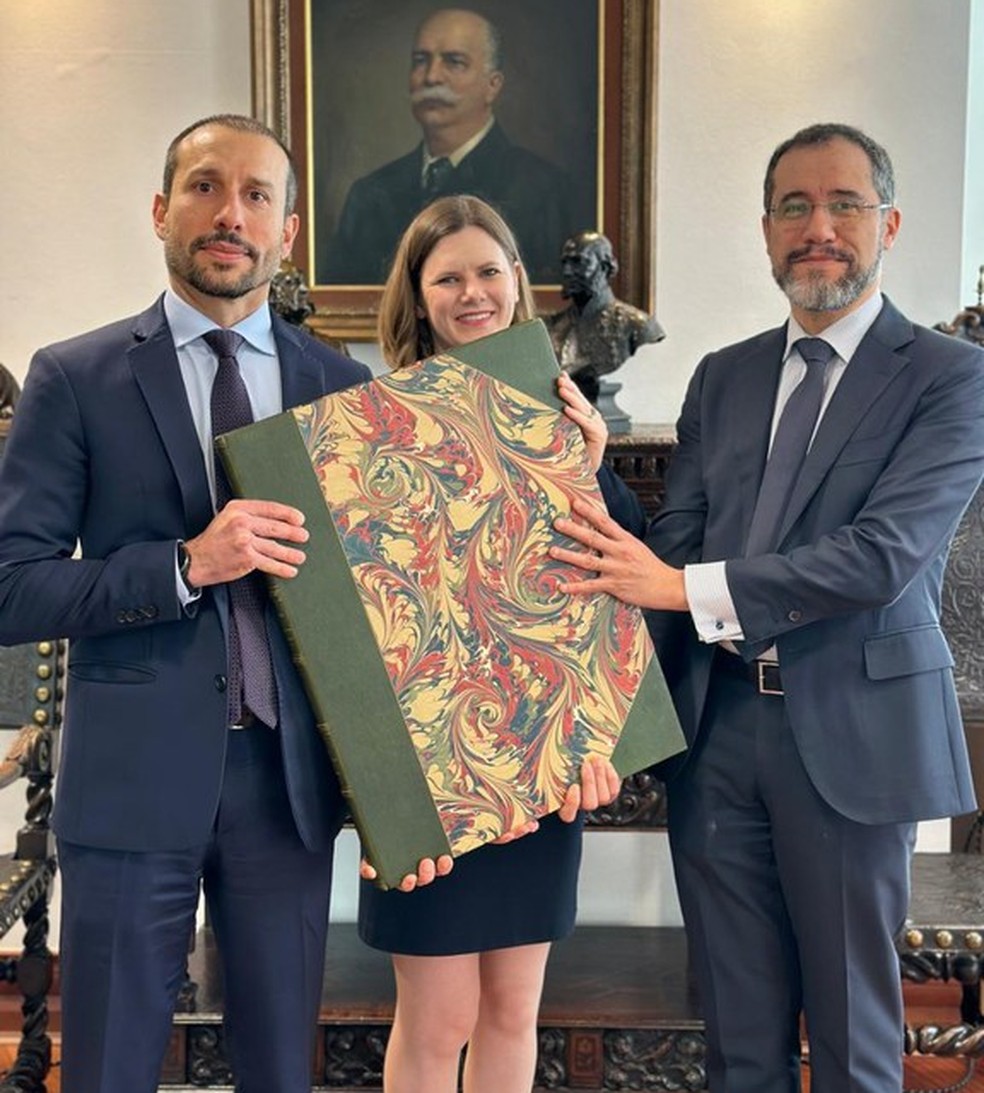 Policiais federais e diplomatas brasileiros com livro histórico recuperado em Londres — Foto: PF/Divulgação