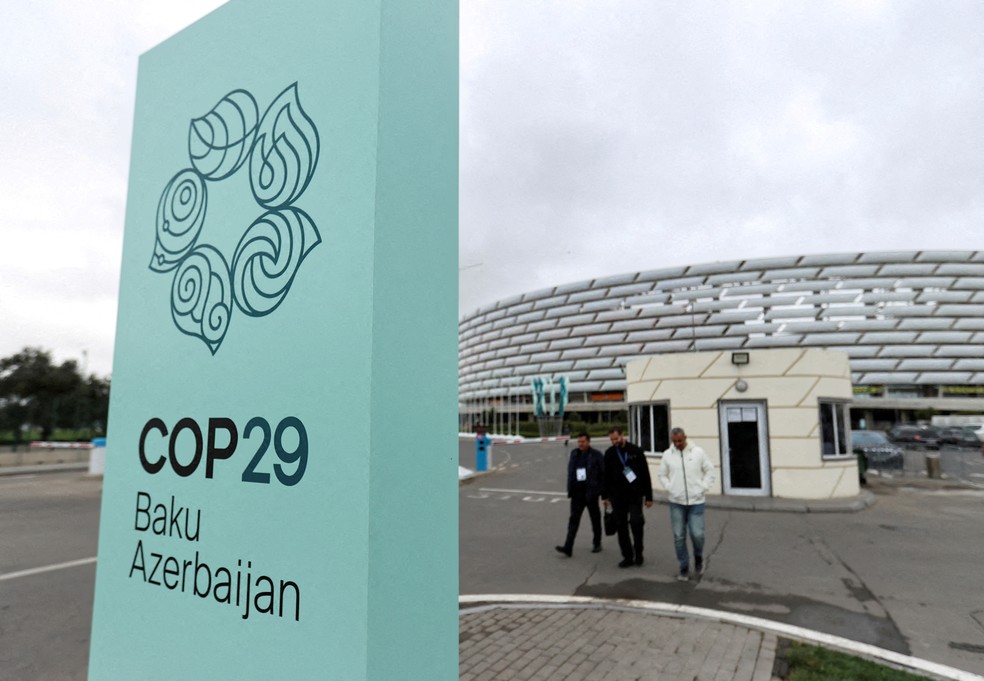 Pedestres caminham perto do Estádio Olímpico de Baku, local onde será realizada a 29ª Conferência das Nações Unidas sobre Mudança Climática, a COP29, em Baku, capital Azerbaijão. — Foto: REUTERS/Aziz Karimov