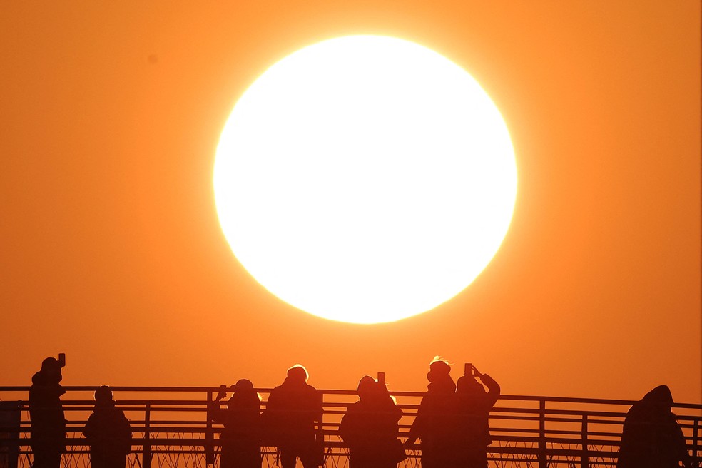 Pessoas tiram fotos do primeiro nascer do sol do ano em um parque em Seul, Coreia do Sul, em 1º de janeiro de 2023 — Foto: REUTERS/Kim Hong-Ji
