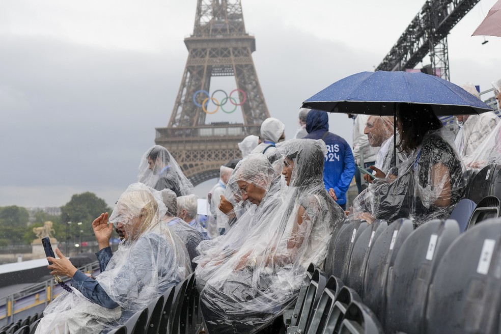Sob chuva, público aguarda cerimônia de abertura das Olimpíadas, em Paris — Foto: Thibault Camus/AP