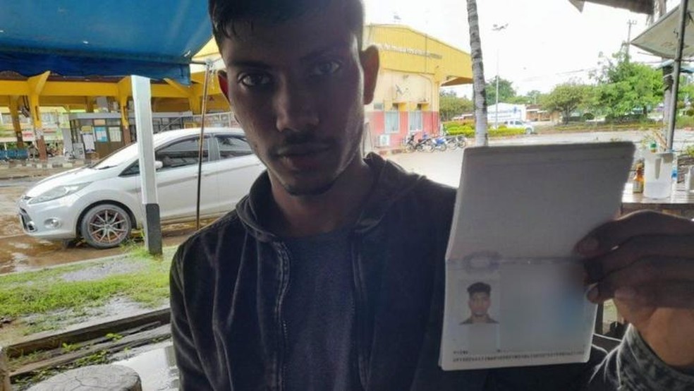 Indiano que foi traficado para Mianmar mostra seu passaporte — Foto: NOPPORN WICHACHAT