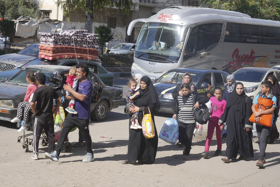 Famílias saem às pressas da Cidade de Gaza nesta sexta-feira (13) após prazo dado por Israel para retirada de civis do norte do território palestino. — Foto: Hatem Moussa/AP