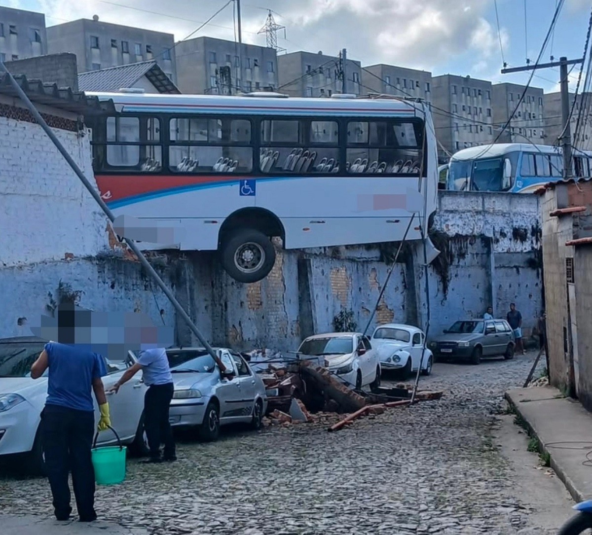 Ônibus fica dependurado em muro após mecânico passar mal durante manobra em MG; VÍDEO