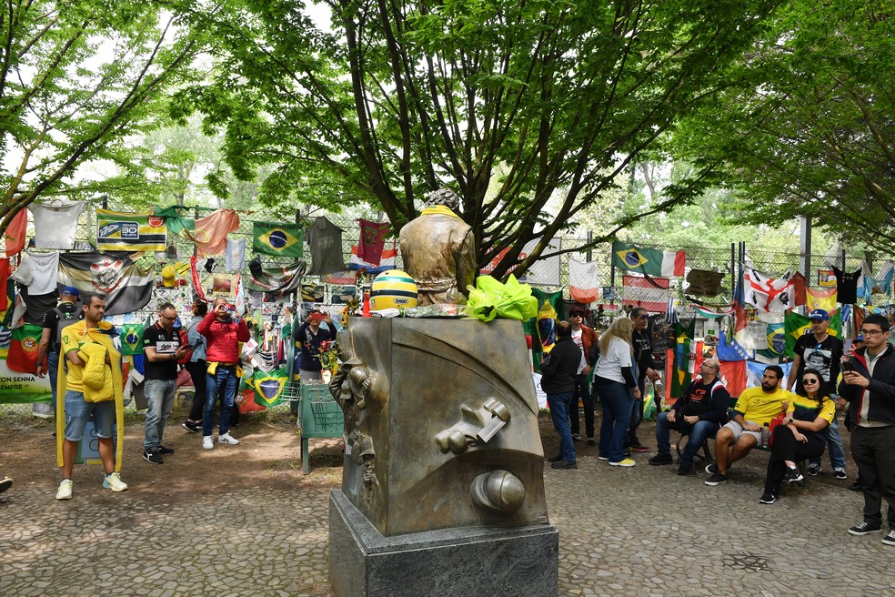 Fãs prestam homenagens a Ayrton Senna em frente à estátua do piloto no Parco delle Acque Minerale, em Imola, na Itália — Foto: Jennifer Lorenzini/Reuters