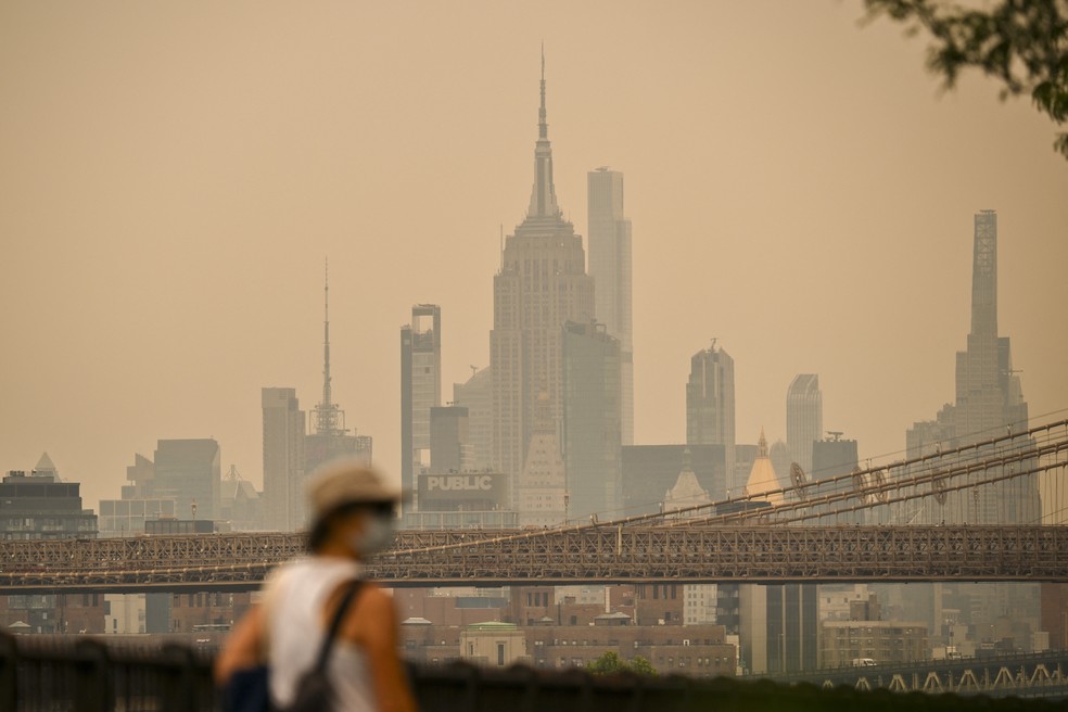 Pedestre usa máscara em meio a poluição em Nova York; qualidade do ar está baixa na cidade devido à fumaça de incêndios florestais no Canadá — Foto: Angela Weiss/AFP