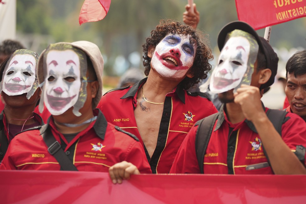 Trabalhadores pintados com o rosto do personagem Coringa durante ato do Dia do Trabalho em Jacarta, Indonésia, quinta-feira, 1º de maio de 2025 — Foto: AP Photo/Tatan Syuflana