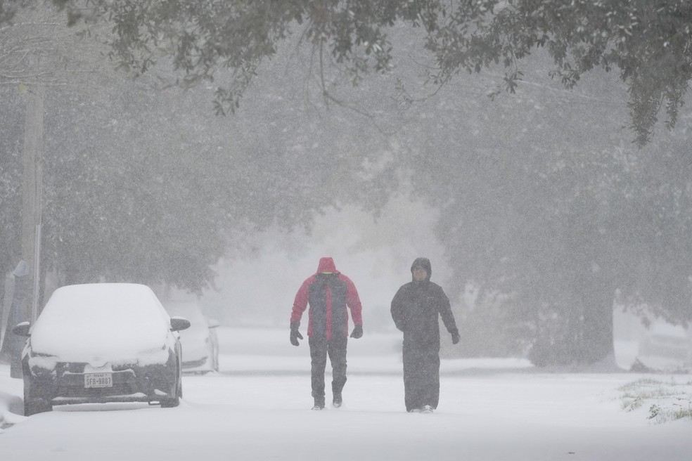 Pessoas caminham sob nevasca em Nova Orleans — Foto: Ashley Landis/AP Photo