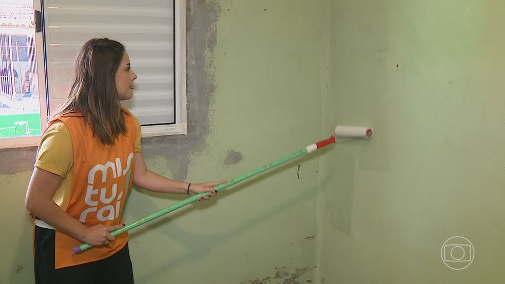 Voluntários pintam casas de Porto Alegre que ficaram debaixo d'água na enchente histórica do RS — Foto: Reprodução/TV Globo