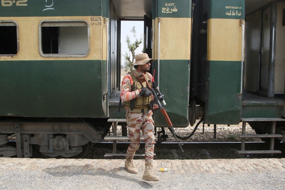 Soldado do Exército do Paquistão fica de guarda ao lado de um trem de resgate em estação próxima a local onde sequestradores fazem passageiros de reféns no estado de Baluchistão, no Paquistão, em 12 de março de 2025. — Foto: REUTERS/Naseer Ahmed