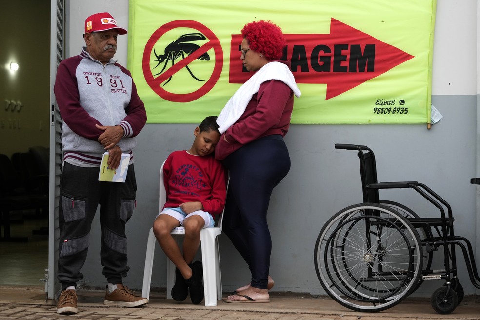 Família espera atendimento do lado de fora de um hospital de campanha militar temporário para o tratamento de pacientes com dengue, no bairro Ceilândia, em Brasília, na sexta-feira, 16 de fevereiro de 2024. — Foto: AP Photo/Eraldo Peres