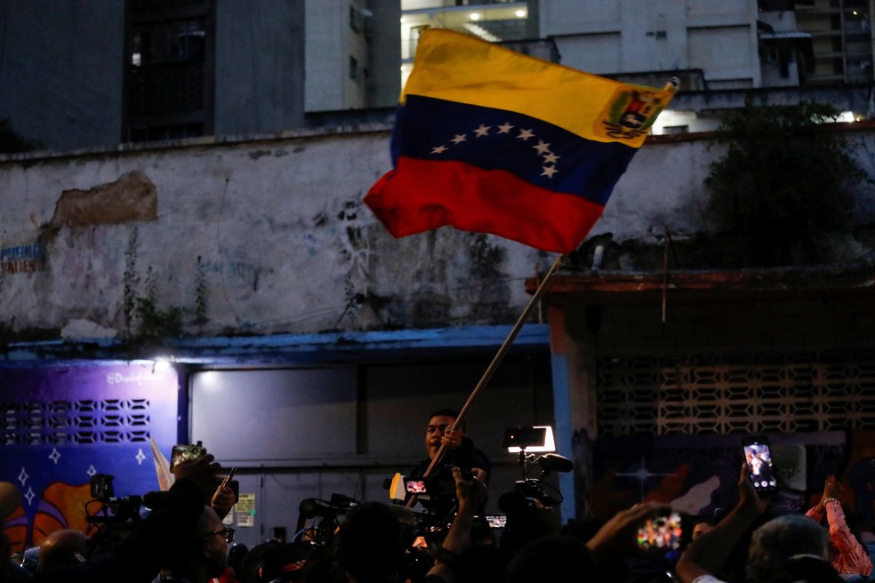Homem agita bandeira da Venezuela em Caracas — Foto: Leonardo Fernandez Viloria/Reuters