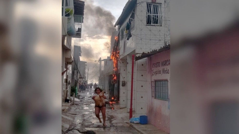 Mulher corre com cão nos braços para fugir de incêndio em fiação no Bairro Cais do Porto, em Fortaleza — Foto: Arquivo pessoal