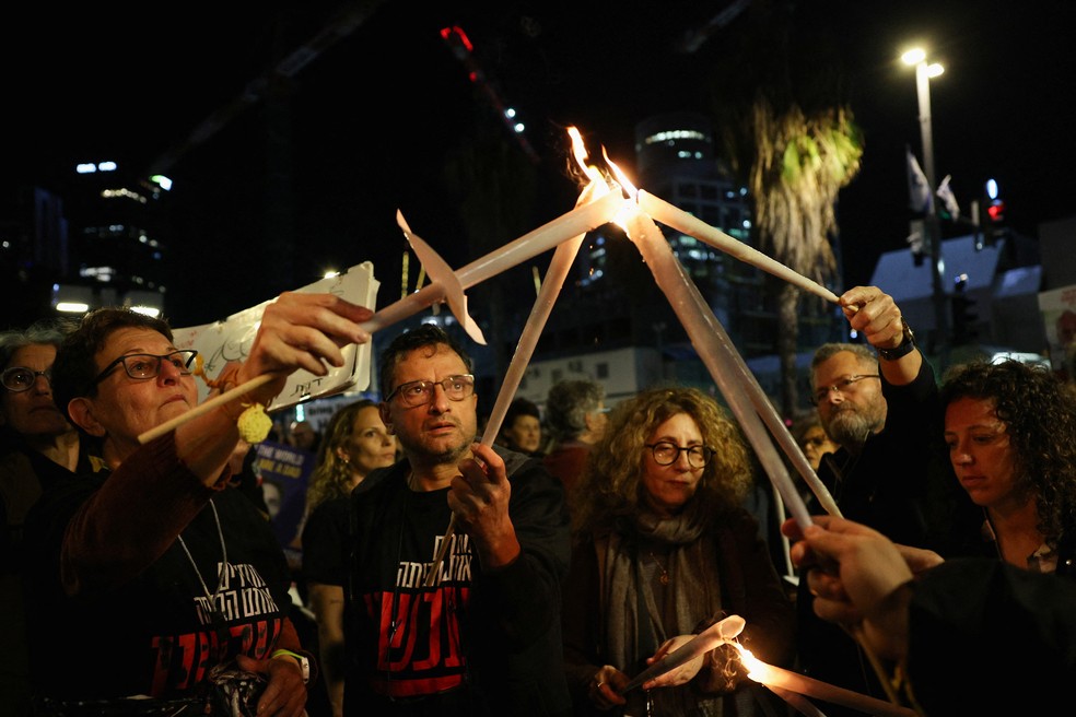 Manifestantes carregaram cartazes, velas e marcharam pelas ruas de Tel Aviv — Foto: Reuters