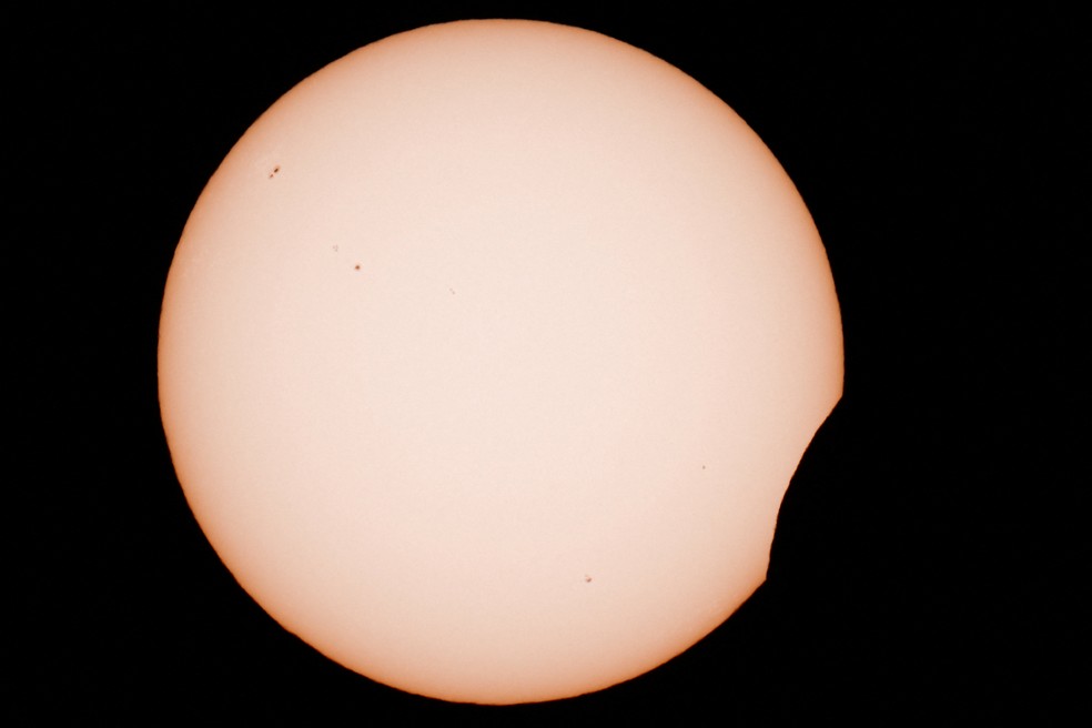 A Lua encobre parcialmente o Sol durante o eclipse solar visto de Arija, na Espanha, nesta quarta-feira (12). — Foto: Borja Suarez/Reuters