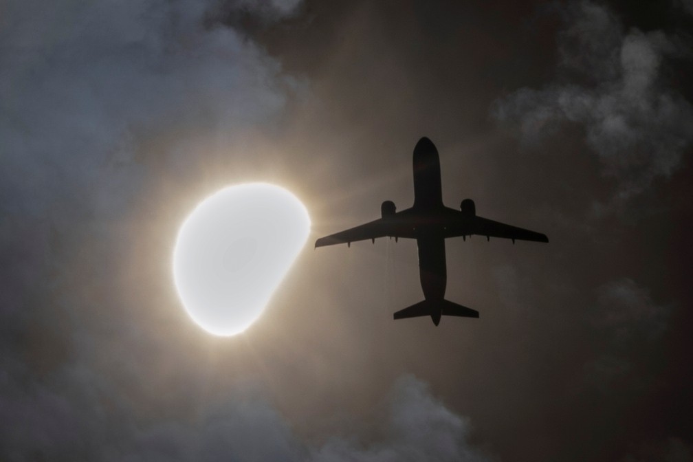 Avião cruza o céu durante momento do eclipse em Nova York — Foto: Andrew Kelly/Reuters
