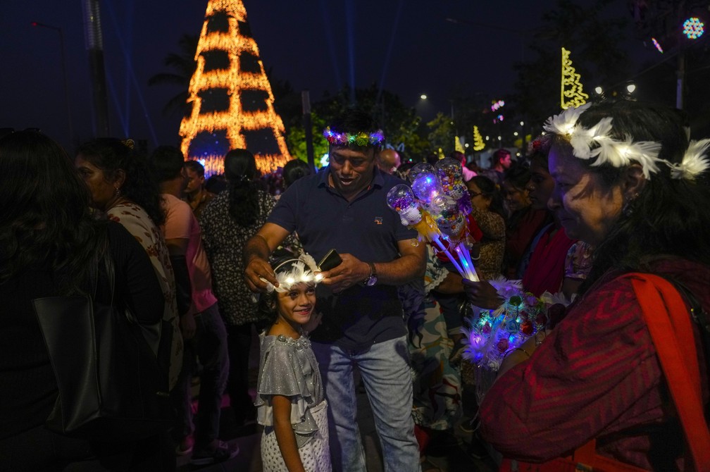 Pessoas compram chapéus decorados para comemorar a chegada do ano novo em Mumbai, na Índia. — Foto: Rafiq Maqbool/ AP