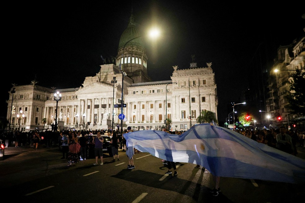 Homem segura bandeira da Argentina diante do Congresso do país em Buenos Aires em 21 de dezembro de 2023 — Foto: Agustin Marcarian/REUTERS