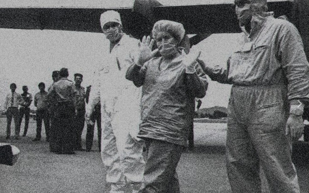 Pessoas com roupas de proteção são conduzidas durante operação de isolamento após contaminação pelo Césio 137, em Goiânia, em 1987 — Foto: Acervo/O Popular