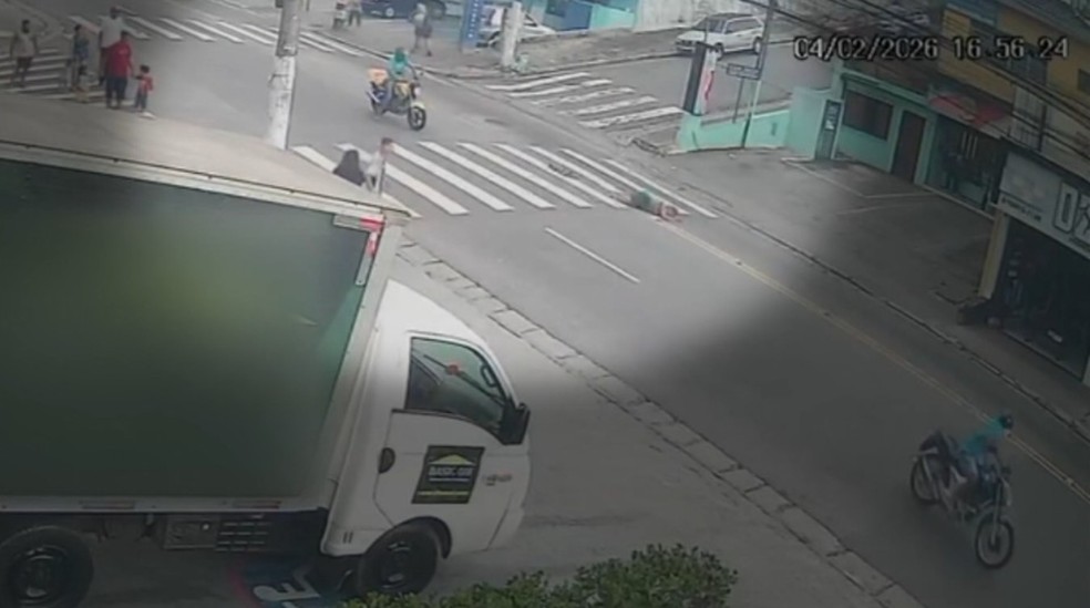 Motociclista empinando moto atropela mulher na faixa de pedestres e foge — Foto: Reprodução/TV Globo