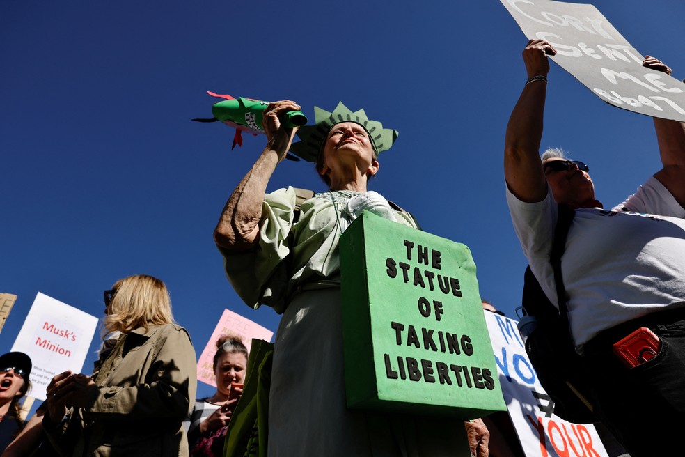 Manifestante em Londres vestido de Estátua da Liberdade com dizeres: a estátua que está tirando liberdades, em protesto contra Trump — Foto: Carlos Jasso/Reuters