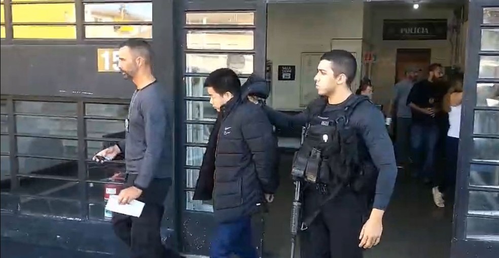 Qiu sendo levado da delegacia em São Paulo para voltar ao Rio de Janeiro — Foto: Reprodução