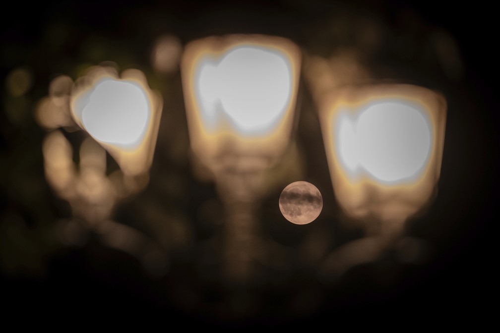 A superlua aparece por trás das luzes parisienses. — Foto: AP