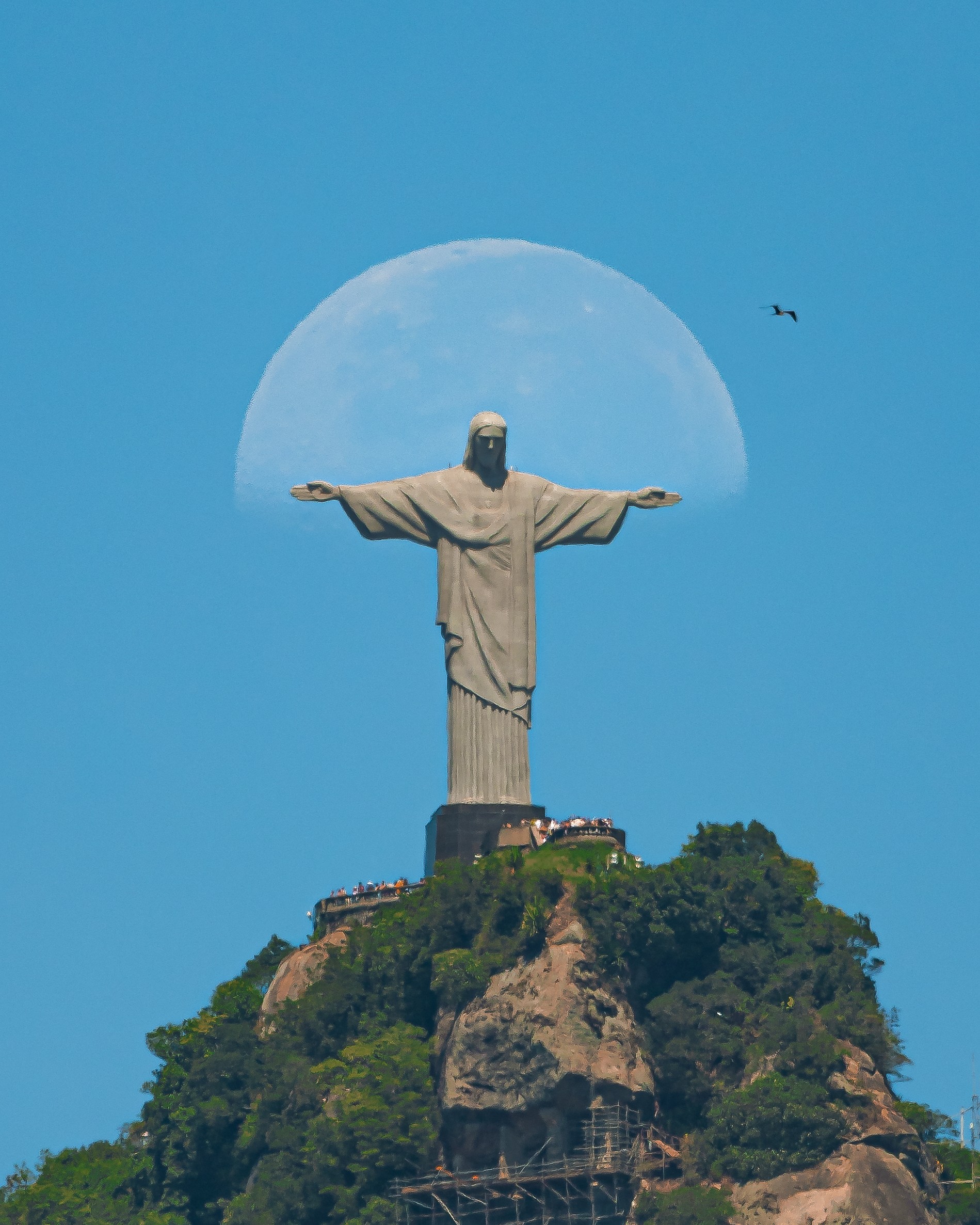 Com céu claro, fotógrafo registra lua 'abraçando' o Cristo Redentor
