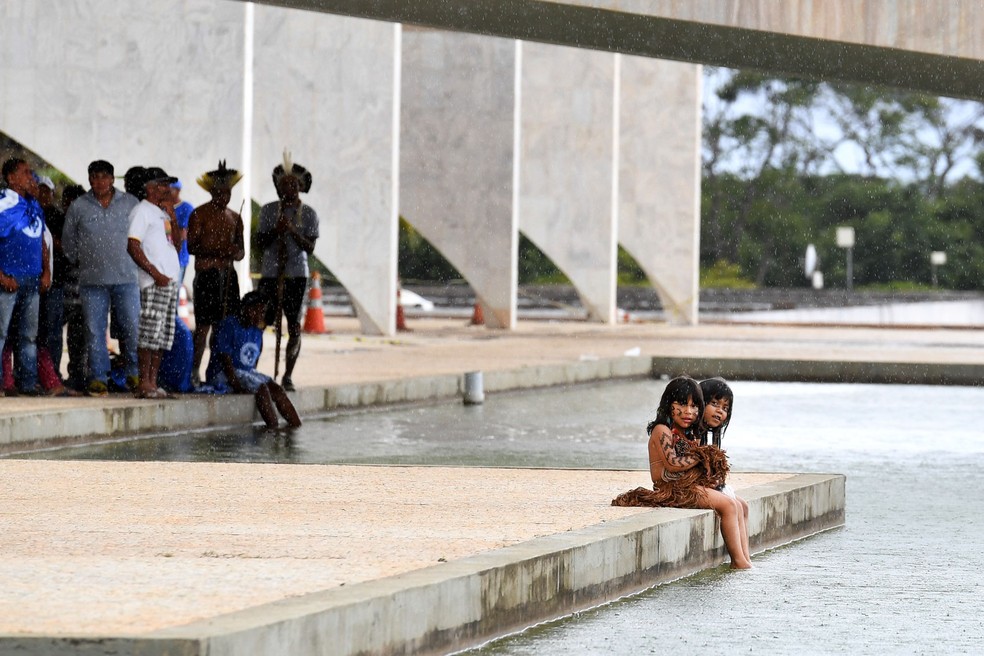 Crianças indígenas molham os pés no espelho d'água do Palácio do Planalto, em Brasília, em imagem de 2016 — Foto: Evaristo Sá/AFP