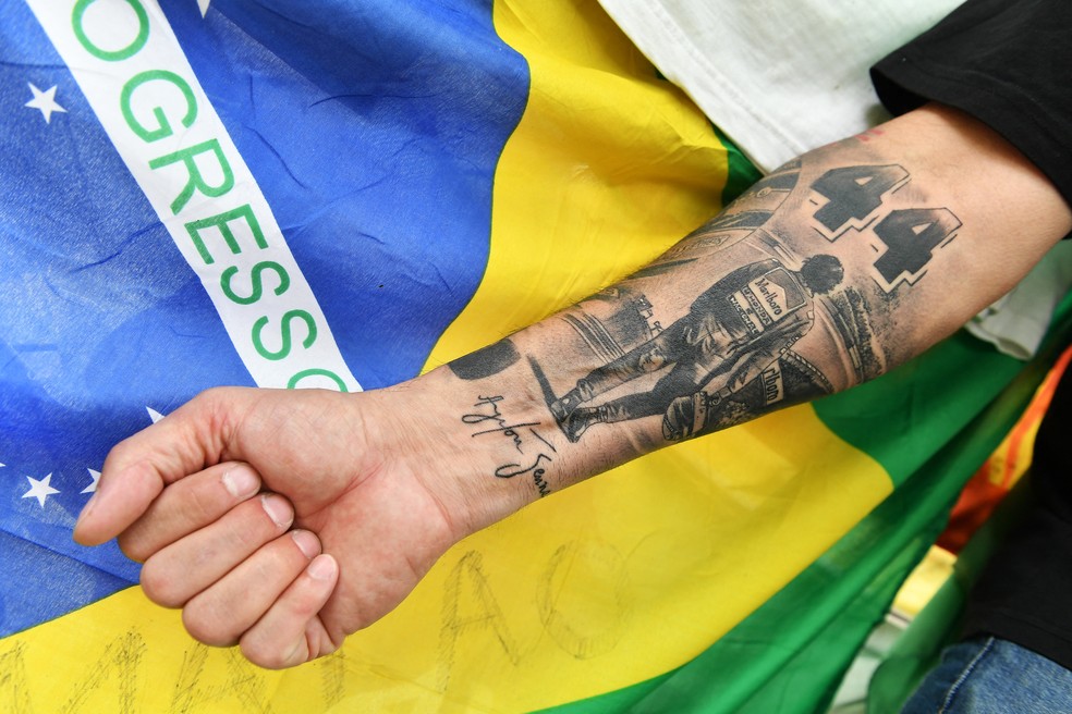 Fã que foi prestar homenagem a Ayrton Senna em Imola nos 30 anos da morte do piloto mostra tatuagem em homenagem ao tricampeão — Foto: Jennifer Lorenzini/Reuters