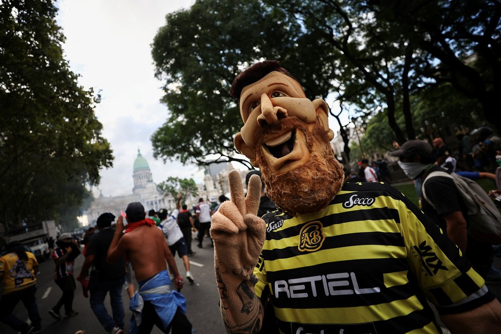 Torcedor usa máscara de Messi durante protesto de aposentados em Buenos Aires — Foto: REUTERS/Agustin Marcarian
