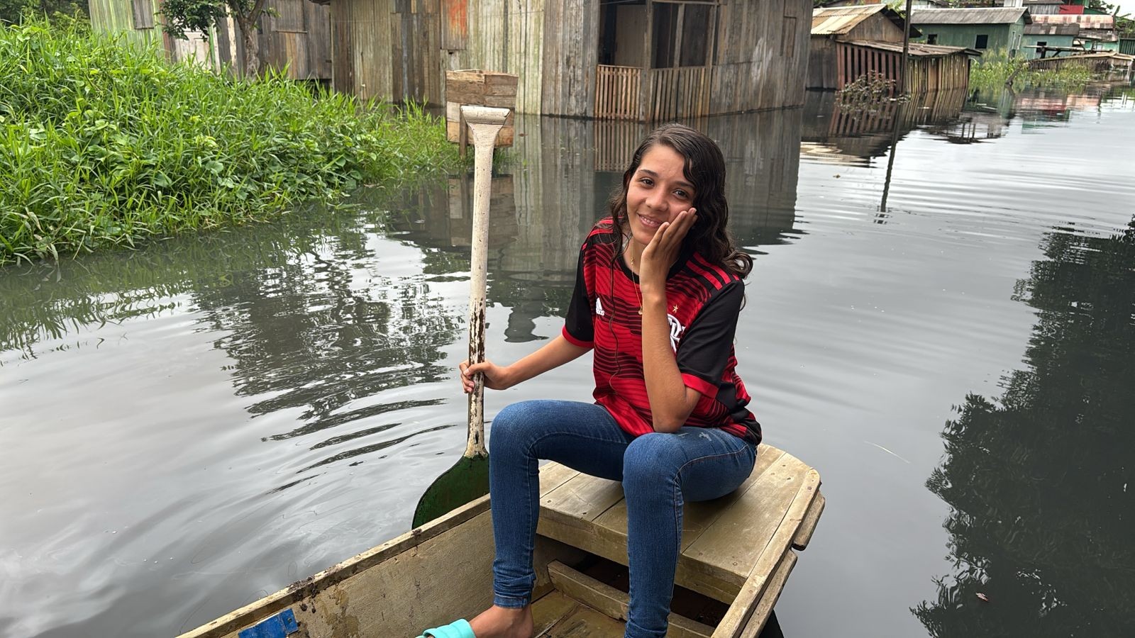 De canoa, adolescente de 17 anos ajuda no transporte de vizinhos em bairro alagado em Rio Branco