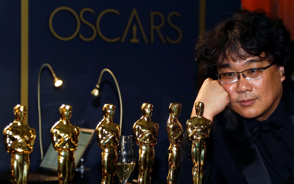 Bong Joon-Ho admira as estatuetas que ganhou no Oscar 2020 — Foto: Eric Gaillard/Reuters