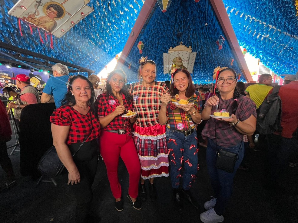 Dançarinas da maior quadrilha junina do Brasil comendo maior bolo de milho do Brasil, em Campina Grande — Foto: Bruna Couto / g1