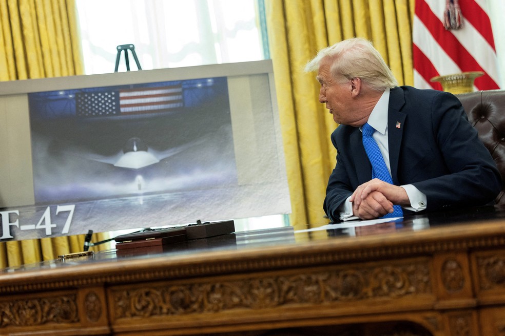 Donald Trump, faz comentários, enquanto uma imagem de um caça F- 47 de sexta geração é exibida, no Salão Oval da Casa Branca, em Washington — Foto: REUTERS/Carlos Barria