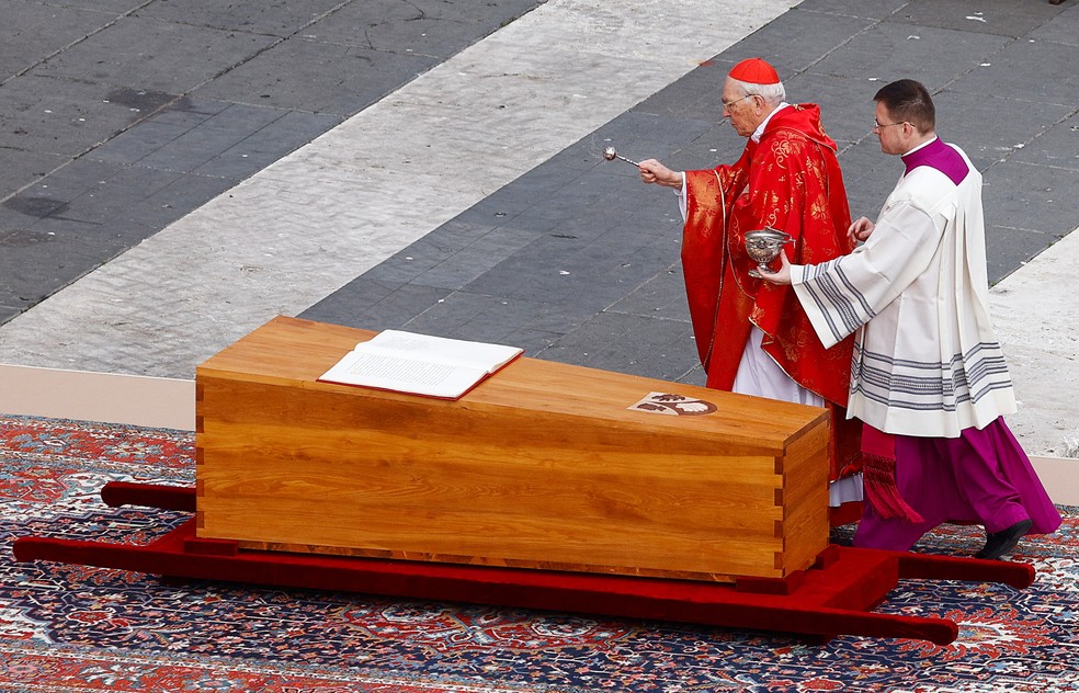 Cardeal Giovani Battista benze o caixão de Bento XVI durante o funeral do papa emérito, em 5 de janeiro de 2023.  — Foto: Guglielmo Mangiapane/ Reuters
