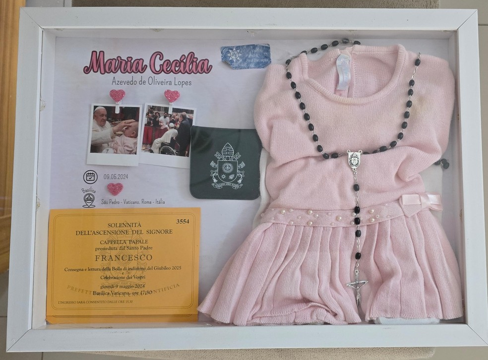 O casal guarda até hoje, com carinho e devoção, a roupa que a filha Maria Cecília usava quando foi abençoada pelo Papa Francisco no Vaticano, em 2024. — Foto: Arquivo pessoal/Eduardo de Oliveira Lopes