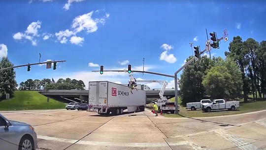 VÍDEO: Homem é atingido por carreta enquanto fazia manutenção de semáforo nos EUA e fica pendurado de ponta-cabeça - Acidente aconteceu na cidade de Denham Springs na última quarta-feira (25). O operário não se feriu.