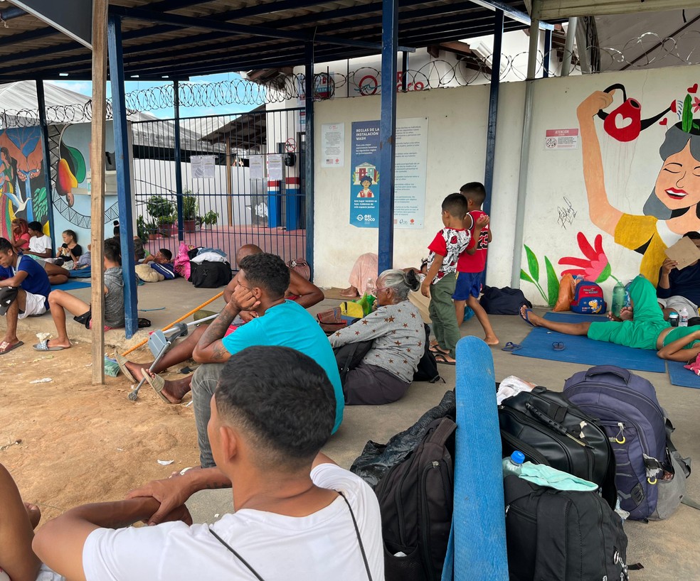 Migrantes sentados na frente de instalação de ajuda humanitária fechada em Boa Vista, em Roraima. — Foto: Yara Ramalho/g1 RR