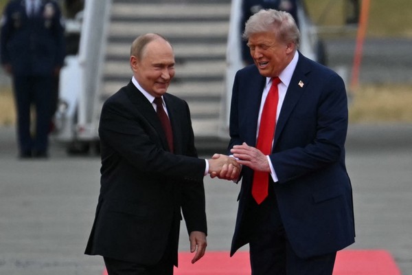 Putin e Trump rindo após se encontrarem — Foto: ANDREW CABALLERO-REYNOLDS / AFP