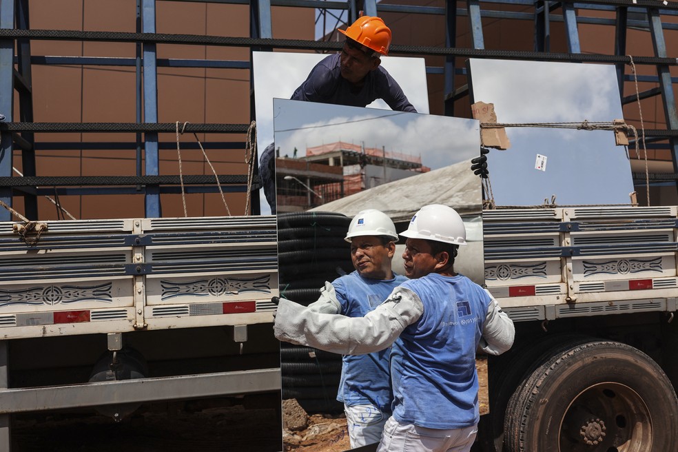 Trabalhadores atuam na construção da Villa COP, próximo ao local da conferência climática da ONU em Belém (PA), que receberá delegações estrangeiras durante a COP30. — Foto: Anderson Coelho/AFP