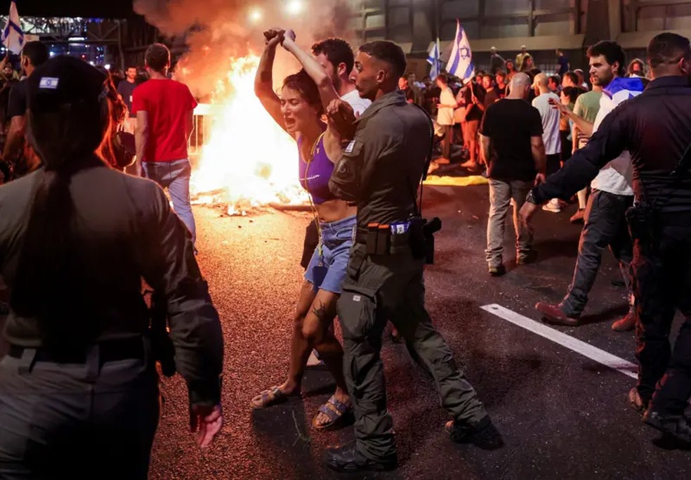 Protestos de domingo foram em grande parte pacficos, mas momentos de maior tenso foram registrados em Tel Aviv aps manifestantes colocarem fogo em barricadas — Foto: Reuters/BBC