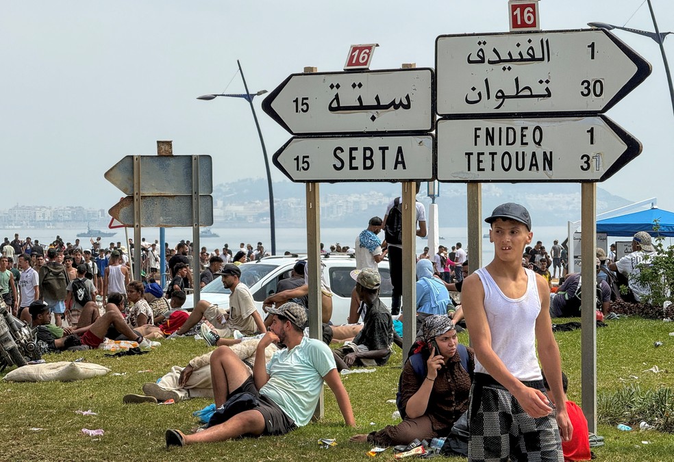 Migrantes descansam após cruzarem de volta do enclave espanhol de Ceuta para o lado marroquino da fronteira em Fnideq, Marrocos — Foto: REUTERS/Stringer