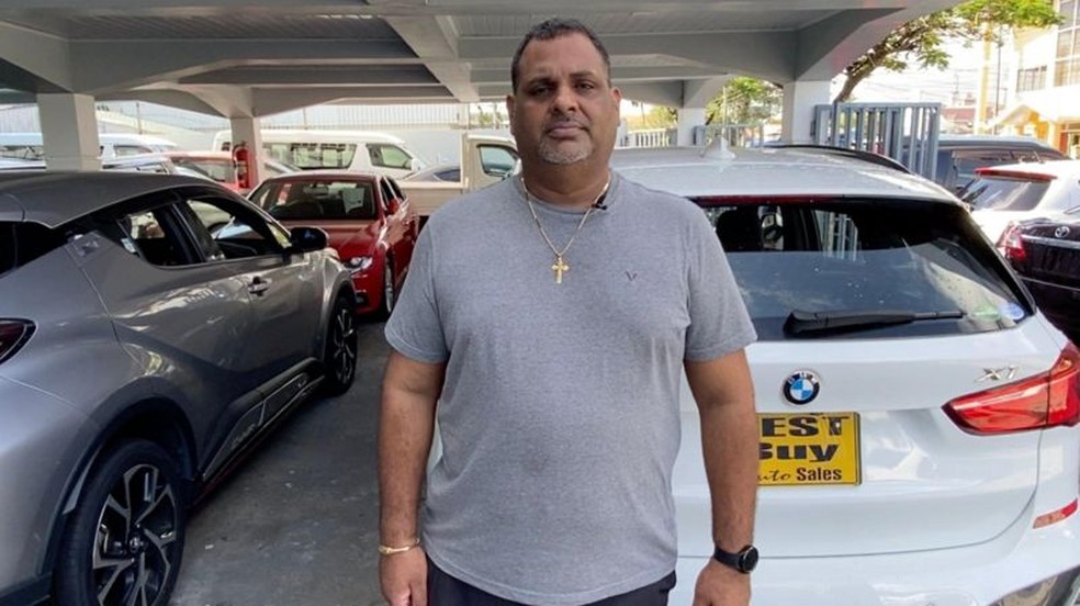 O empresário Richard Singh vende carros importados em Georgetown — Foto: LEANDRO PRAZERES/BBC NEWS BRASIL