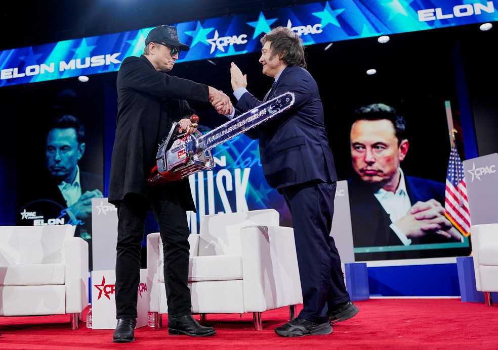 Elon Musk cumprimenta Javier Milei após ganhar motosserra de presente do presidente argentino — Foto: Nathan Howard/Reuters